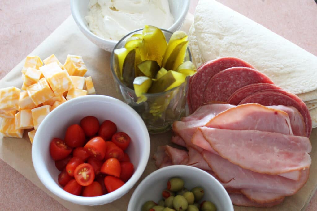 ingredients for ham roll ups with pickles and cheese.