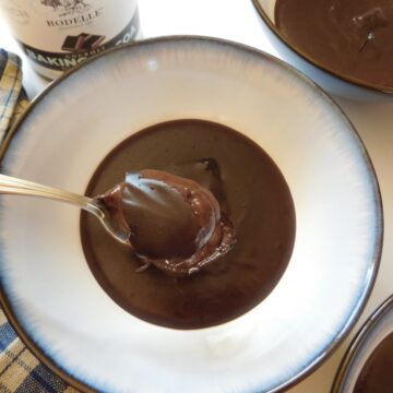 overhead shot of chocolate pudding in a bowl with a spoon holding up a bite.