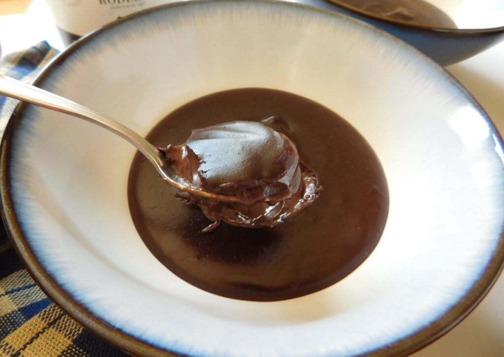 side view of chocolate dessert in a bowl with a spoon in it.