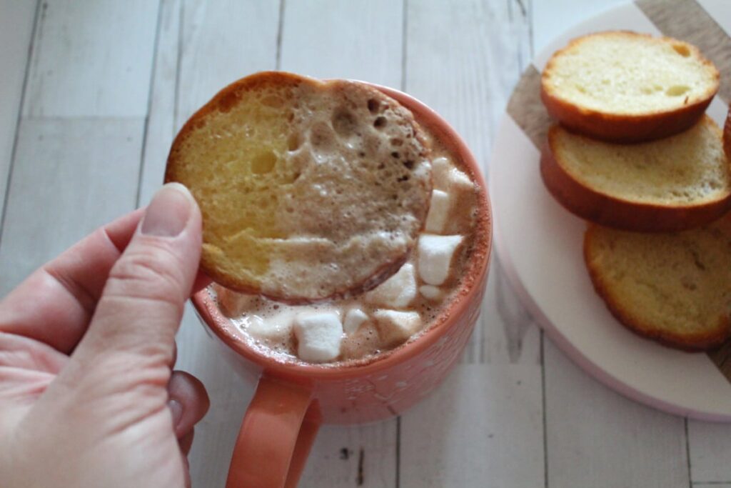 overhead shot of toast dipped into hot cocoa with marshmallows.