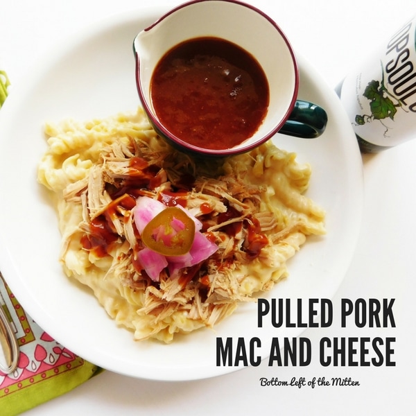 Pulled Pork Mac and Cheese on a plate with some BBQ sauce and a craft beer off to the side.