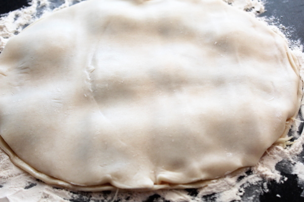 Pie crust with filling in the center ready to be cut.