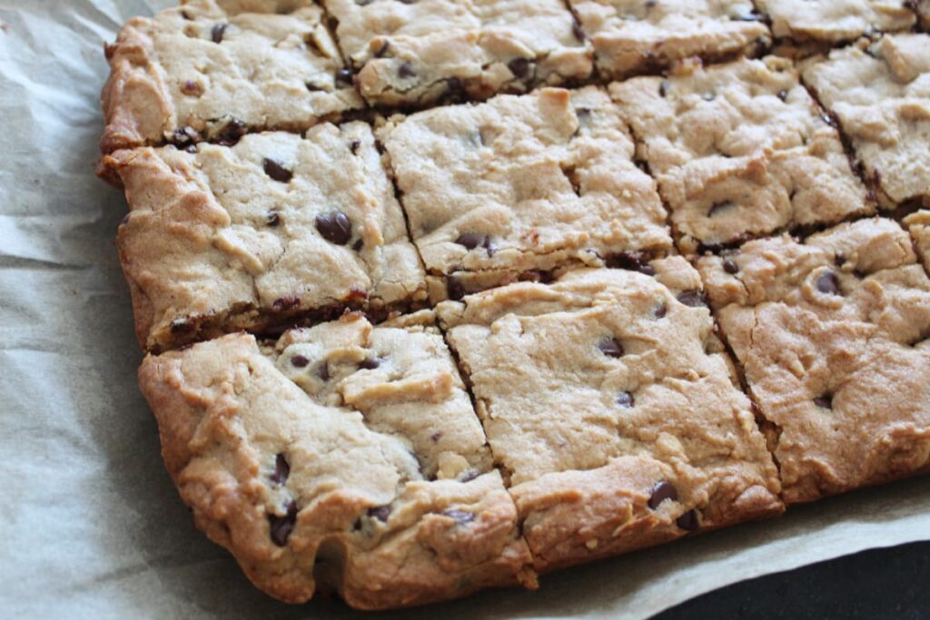 blondies cut into squares on top of a piece of parchment paper.