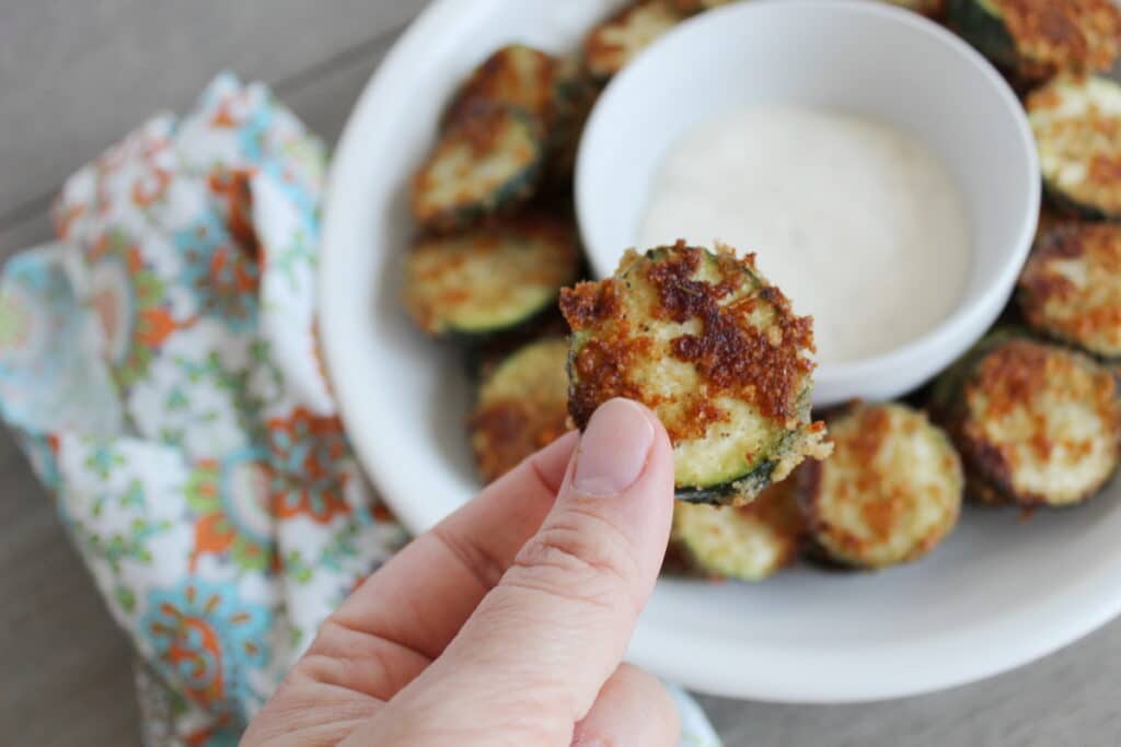 close up of a piece of fried zucchini with ranch on it