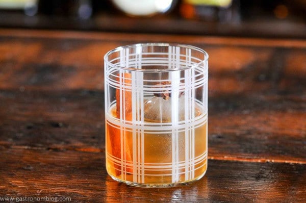 a single glass of Spiced Old Fashioned on a bar countertop 