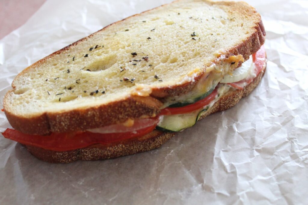 a vegetable sandwich that has been cooked in the air fryer on a piece of wax paper.